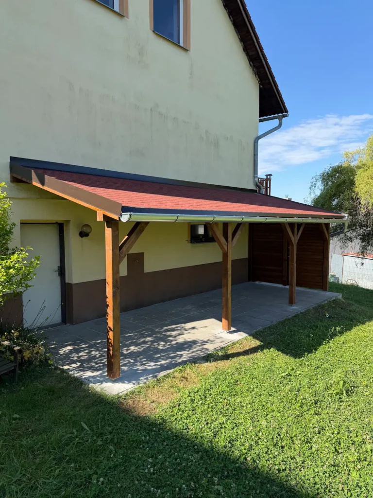 Krytá terasa pod dřevěnou pergolou podél celé boční strany domu